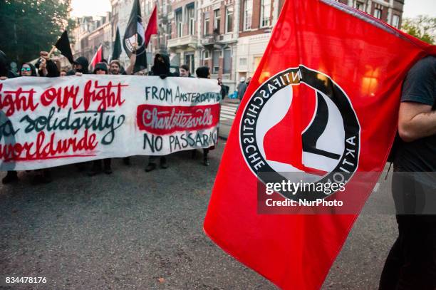 Demonstrators march with a banner during a protest called by the Dutch Antifascist Action AFA against the violence that took place at the August 12th...