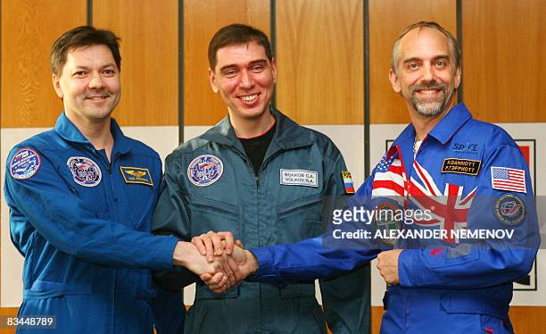 Space tourist Richard Garriott and Russian cosmonauts Sergei Volkov and Oleg Kononenko cshake hands at a press conference at Star City outside Moscow...