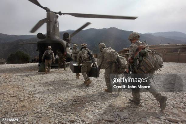 Soldiers board an Army Chinook transport helicopter after it brought fresh soldiers and supplies to the Korengal Outpost on October 27, 2008 in the...