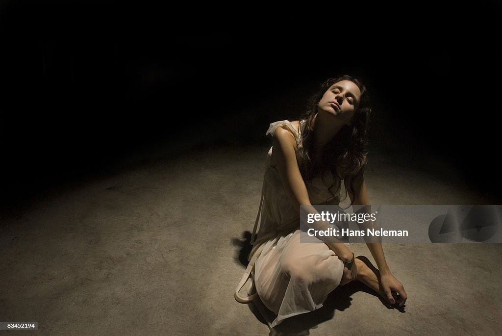 Young woman sitting on pavement