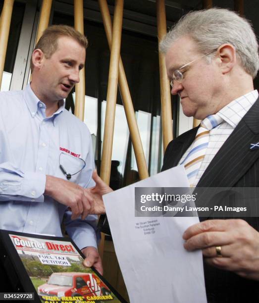 Lorry driver Brian Regan hands a letter to Transport Minister Stewart Stevenson, protesting about the rising cost of fuel outside the Scottish...