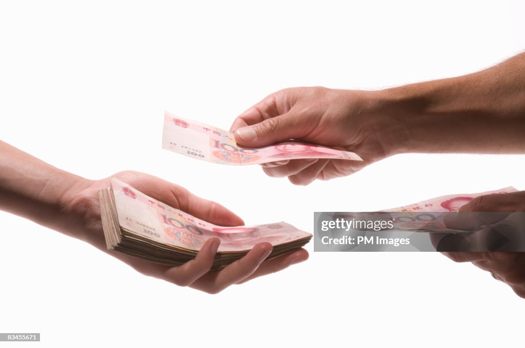 Two men exchanging Yuan banknote