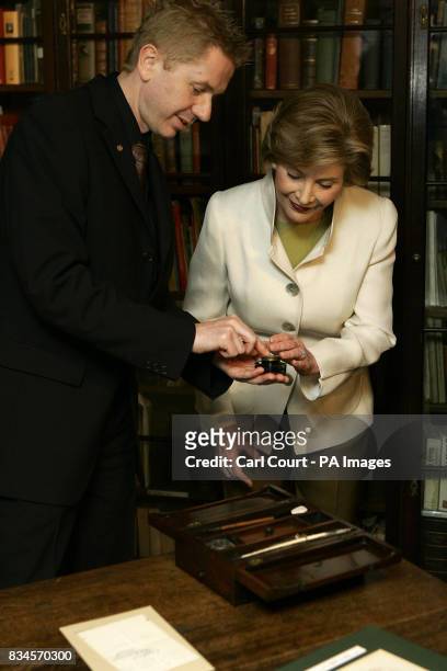 America's First Lady, Laura Bush, right, is shown Charles Dickens inkwell by Andrew Xavier, the museum director, during her visit to the Charles...