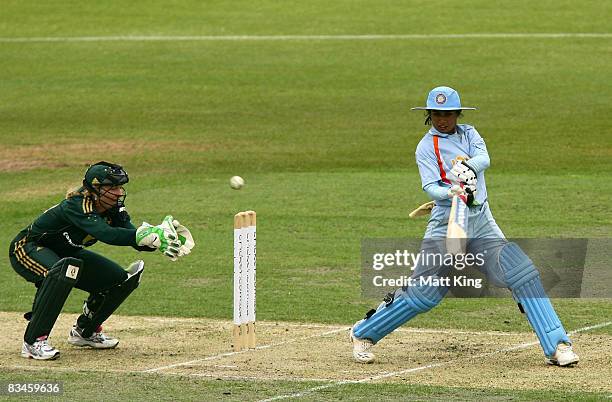 Mithali Raj of India hits out as Jodie Fields of Australia keeps wicket during the Women's Twenty20 International match between the Australian...