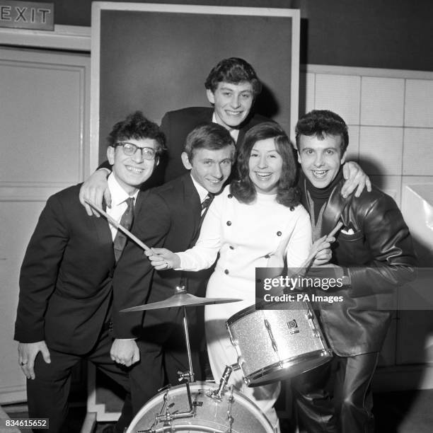 Girl drummer wearing a white leather suit catches the eye in the 'pop' music group, The Ravens, introduced to the press in London this morning. Her...