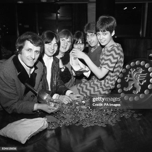 Miss Christine Hall, an 18 year old bank clerk at the Midland Bank Ltd, 220 High Holborn, London, is shown with visitors to the branch. They are 'The...