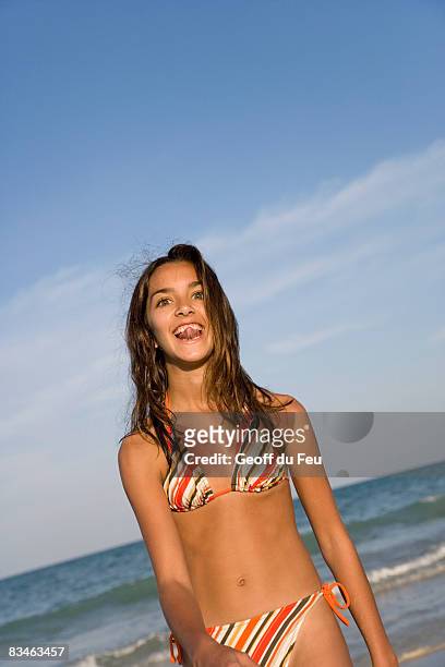 teenage girl (15-16) on beach sticking tongue out - tunisian girls stock-fotos und bilder