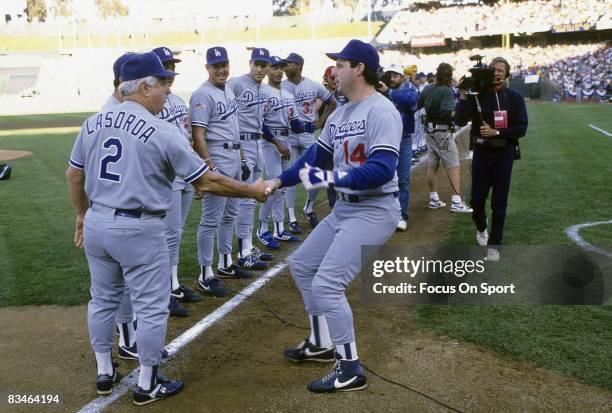 Los Angeles Dodgers catcher Mike Scioscia shake the hand of Manager Tommy Lasorda during player introductions before game 3 of the World Series,...