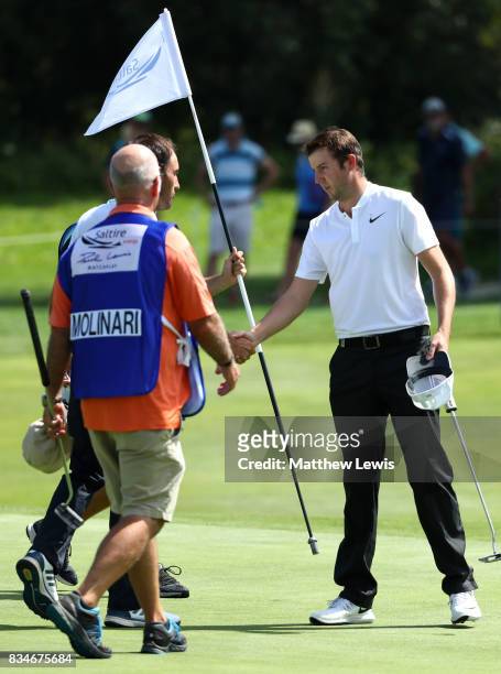 Ashley Chesters of England is congratulated on his victory by Edoardo Molinari of Italy on the 17th green during the 32 qualifiers matches of the...
