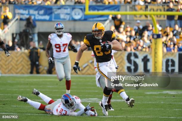 Tight end Heath Miller of the Pittsburgh Steelers runs from cornerback Corey Webster of the New York Giants after catching a pass during a game at...