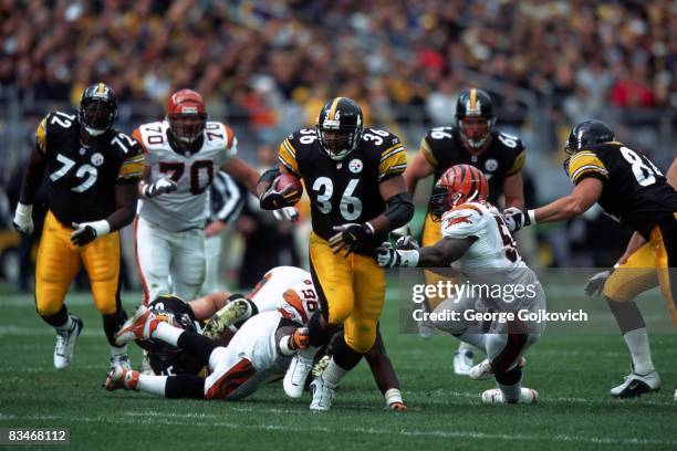 Running back Jerome Bettis of the Pittsburgh Steelers runs from defensive lineman Vaughn Booker and linebacker Takeo Spikes of the Cincinnati Bengals...