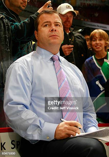 Head coach Alain Vigneault of the Vancouver Canucks sports a pink tie to honour Hockey Fights Cancer as he watches his team during the warmup before...