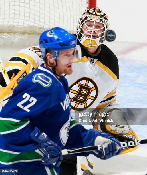 Henrik Sedin of the Vancouver Canucks and Tim Thomas of the Boston Bruins watch the puck after a shot during their game at General Motors Place on...