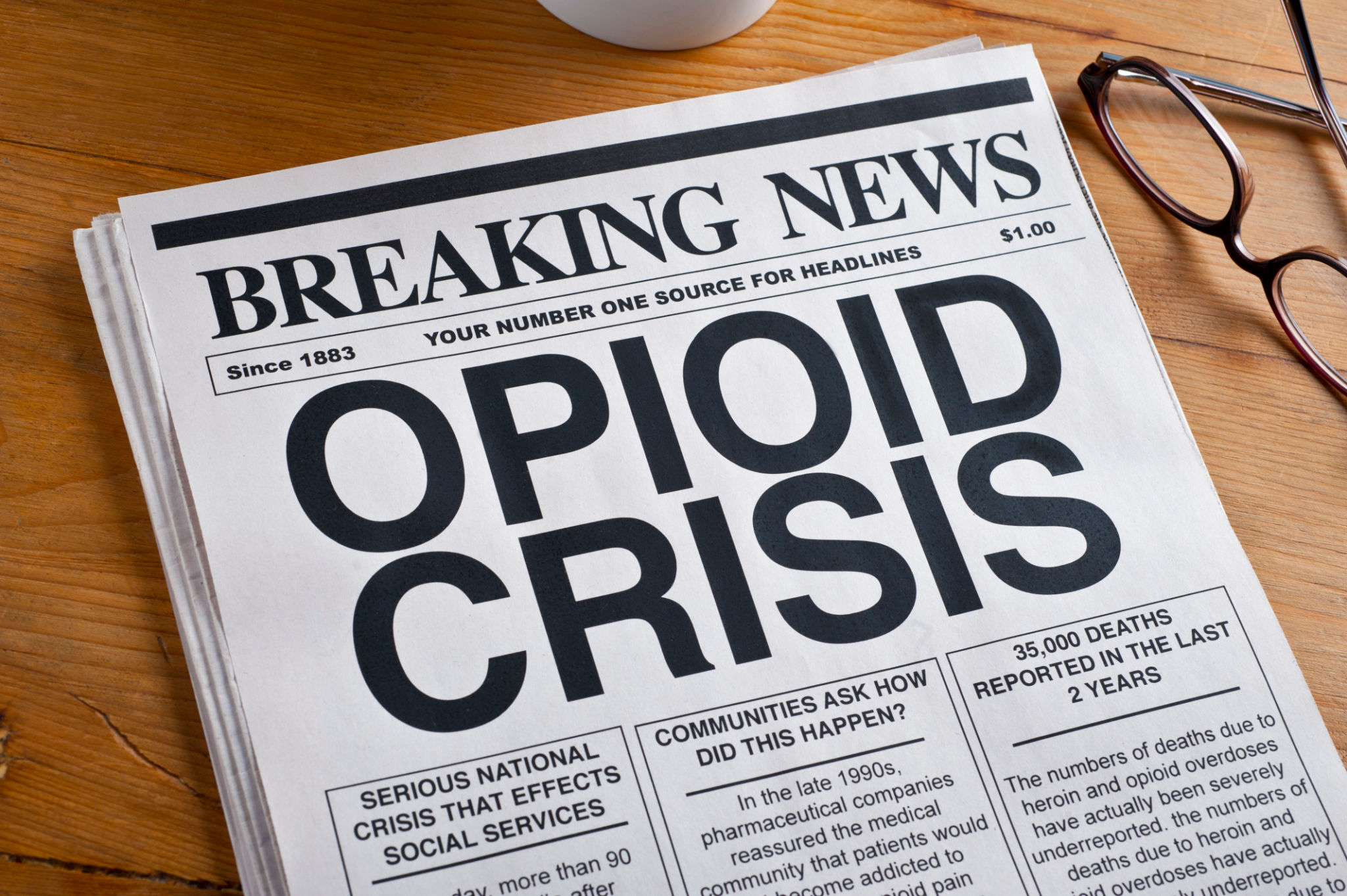 Opioid Crisis Newspaper Headline. Newspaper is on a Desk Opioid Crisis Newspaper Headline. Newspaper is on a Desk