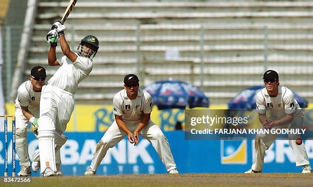 Bangladeshi batsman Shakib Al Hasan plays a shot as New Zealand cricketers Brendon McCullum , Ross Taylor and Jamie How look on during the fifth day...