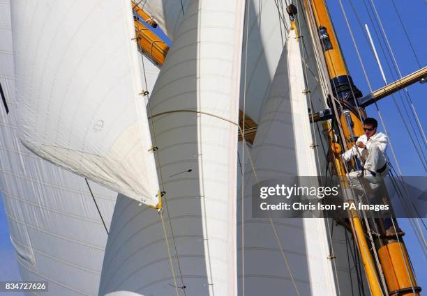 Crew member pictured high above the water on board Mariquita during the round island race on the first day of the British Classic Yacht Club regatta...