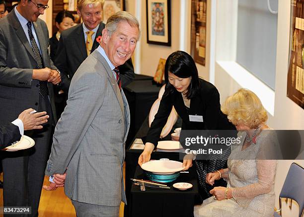 Prince Charles, Prince of Wales and TRH Camilla, Duchess of Cornwall attempt to autograph on a plate at a calligraphy gallery by Japanese artists who...