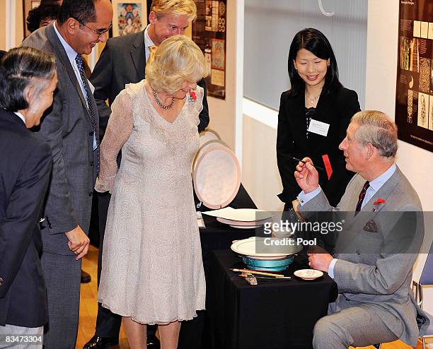 Prince Charles, Prince of Wales and TRH Camilla, Duchess of Cornwall attempt to autograph on a plate at a calligraphy gallery by Japanese artists who...