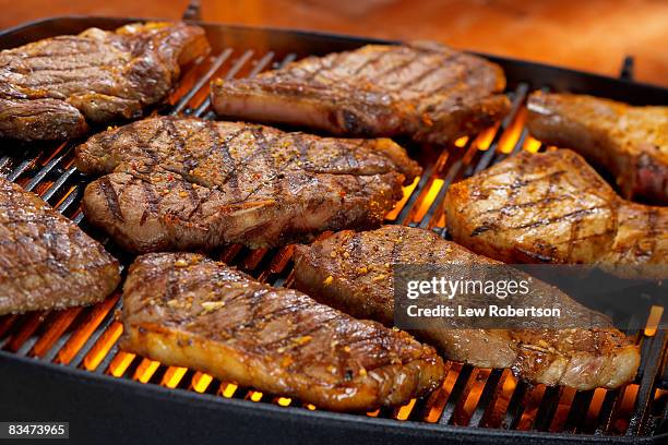 steak and pork chops on grill - schweinekotelett stock-fotos und bilder