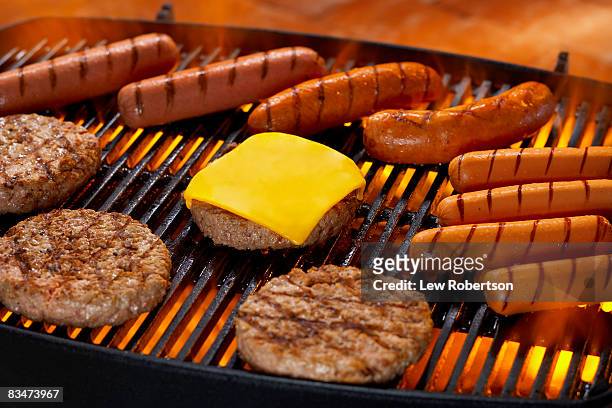 hamburgers and hot dogs on grill - burgers cooking grill stockfoto's en -beelden