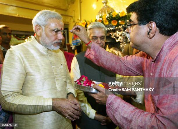 Chief Minister of western India's Gujarat state Narendra Modi receives blessings from Hindu priest Shirish Avasthi at the Bhadrakali temple on the...