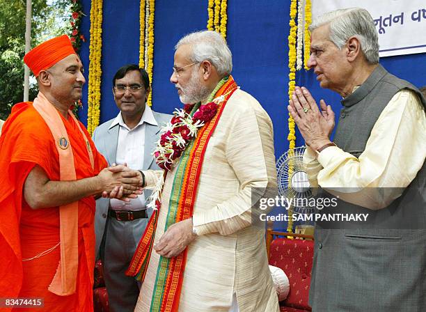 Chief Minister of western India's Gujarat state Narendra Modi is greeted by a Swami priest on the occasion of Diwali in Ahmedabad on October 29,...
