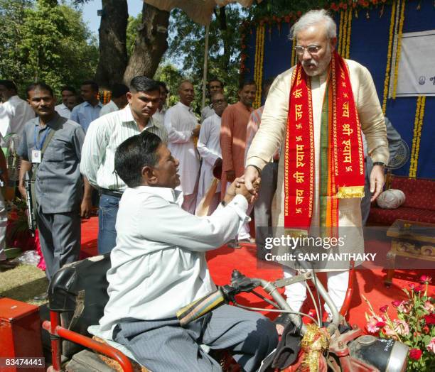 Chief Minister of western India's Gujarat state Narendra Modi is greeted by a physically impaired person during an event on the occasion of Diwali in...