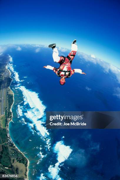 skydiver upsdie down in freefall above ocean. - skydiving pov stock pictures, royalty-free photos & images