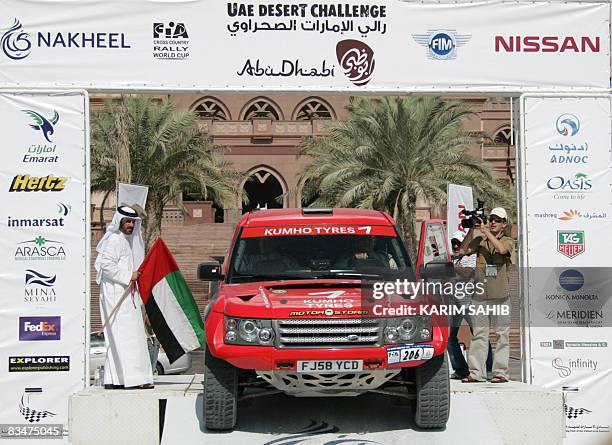 Emirati rally champion Mohammed bin Sulayem , the chairman of the organising committee of the UAE Desert Challenge 2008 rally, holds a national flag...