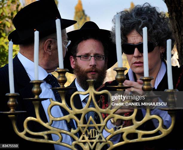 Members of Romanian Jewish comunity, among them Romanian actress Maia Morgenstern , light candles during a religious service at a Jewish cemetery...