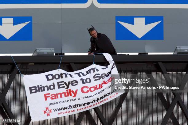 Campaigner, believed to be linked to Fathers 4 Justice, dressed as Batman on a gantry over the M25 near Heathrow Airport, London.