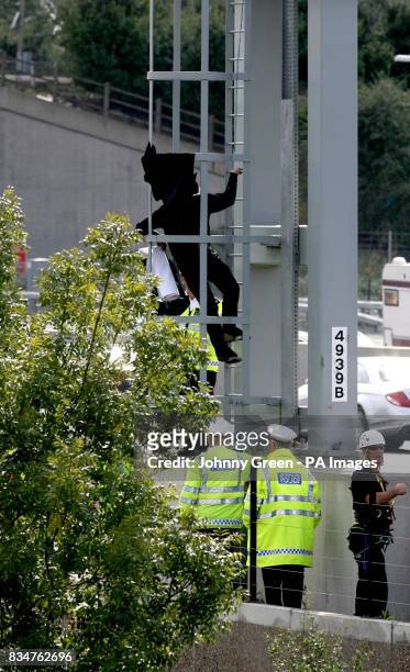 Campaigner, believed to be linked to Fathers 4 Justice, dressed as Batman, climbs down after staging a protest on a gantry over the M25 near Heathrow...
