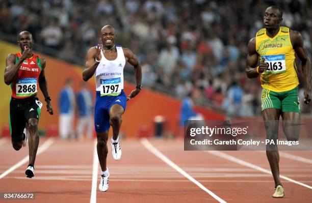 Great Britain's Marlon Devonish trails behind Usain Bolt during the 200 metre heats in the National Stadium in Beijing during the 2008 Beijing...