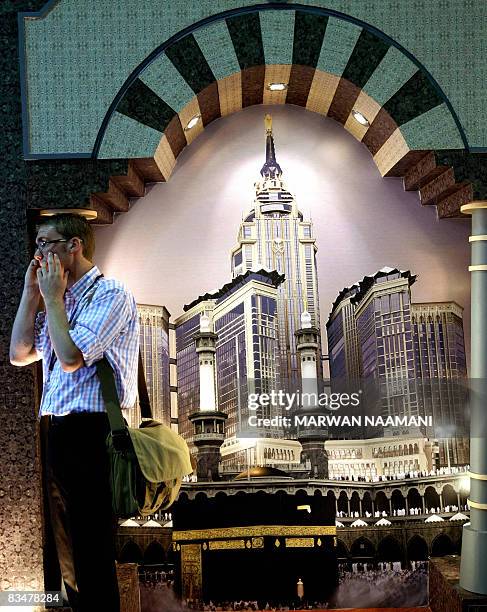 Visitor speaks on the phone near the Saudi Bin Laden Group's Giwar stand on the opening day of the Cityscape 2008 international real estate...