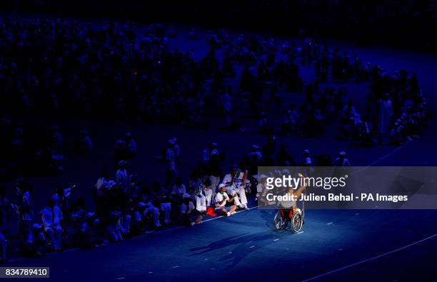 An athlete carries the torch during the Beijing Paralympic Games 2008 Opening Ceremony at the National Stadium, Beijing, China.