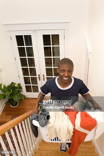 boy carrying laundry up stairs - carrying laundry stock pictures, royalty-free photos & images