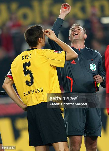 Referee Helmut Fleischer throws the coin at his 150th game and Sebastian Kehl of Dortmund watches him during the Bundesliga match between 1. FC Koeln...