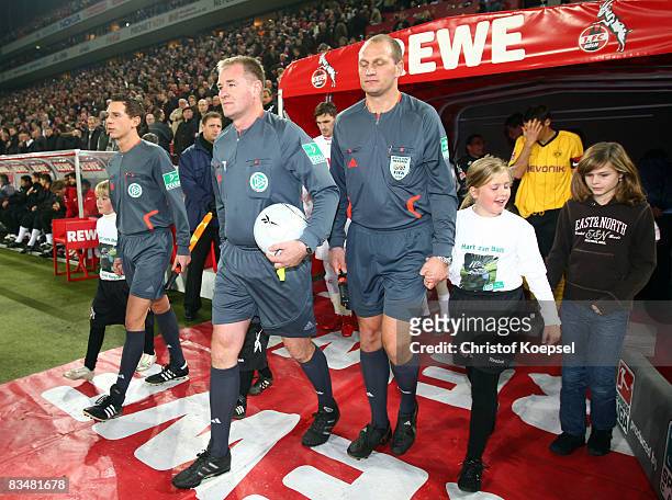 Referee Helmut Fleischer enters the pitch with linesman Christian Bandurski and linesman Soenke Glindemann before the 150th game during the...