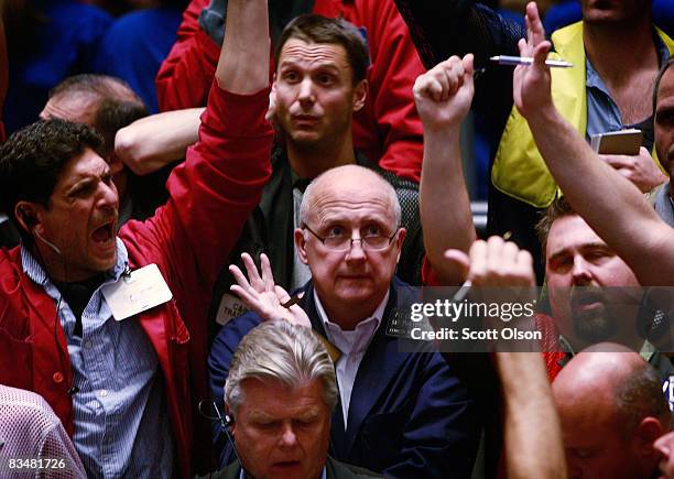 Traders signal offers in the S&P 500 stock index futures pit following the announcement by the Federal Reserve that it would cut the federal funds...