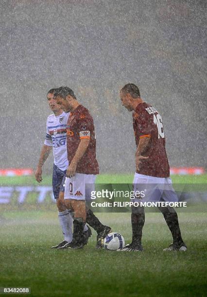 Roma's forward Francesco Totti and middfielder Daniele De Rossi look at the flooded pitch with Sampdoria's foward Antonio Cassano during their Serie...
