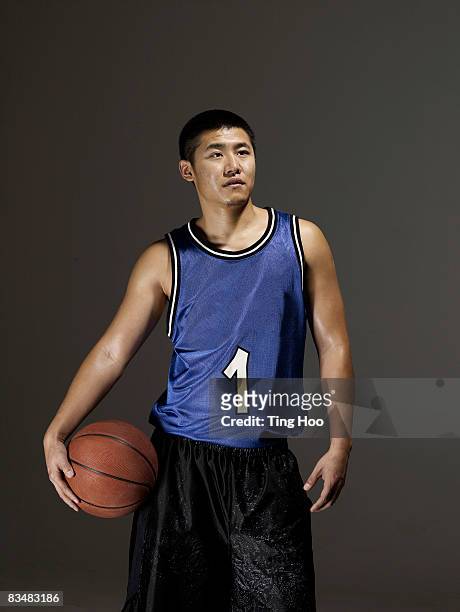 man holding basketball - basketball uniform stock pictures, royalty-free photos & images