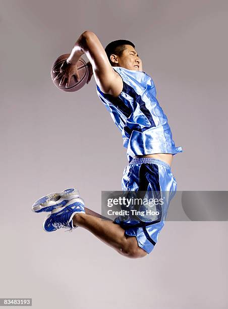 man playing basketball, side view - basketbaltenue stockfoto's en -beelden
