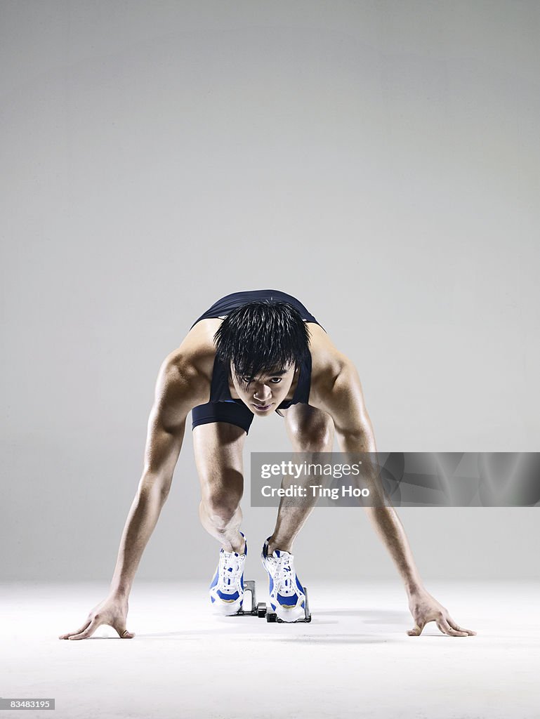 Male runner in starting blocks