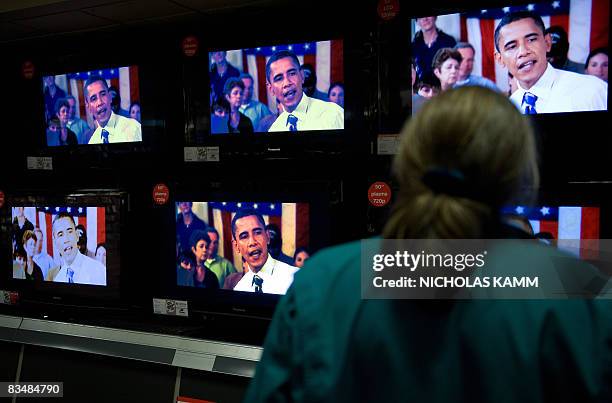 Woman watches US Democratic presidential candidate Barack Obama on television screens at an electronics shop in Wheaton, Maryland, on October 29,...