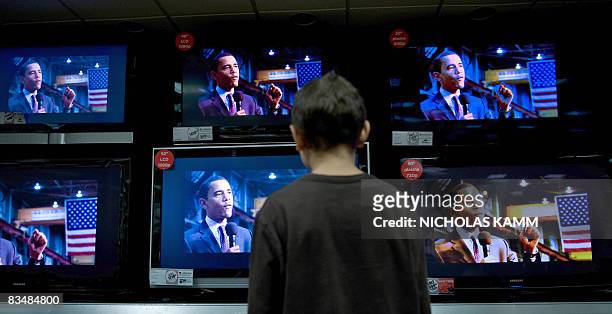 Boy watches US Democratic presidential candidate Barack Obama on television screens at an electronics shop in Wheaton, Maryland, on October 29, 2008...