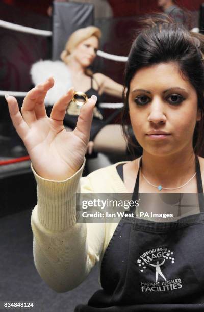 Caryn Bloom, wardrobe and hair assistant at Madame Tussaud's, removes Madonna's wedding ring from her waxwork, at Madame Tussauds in central London.