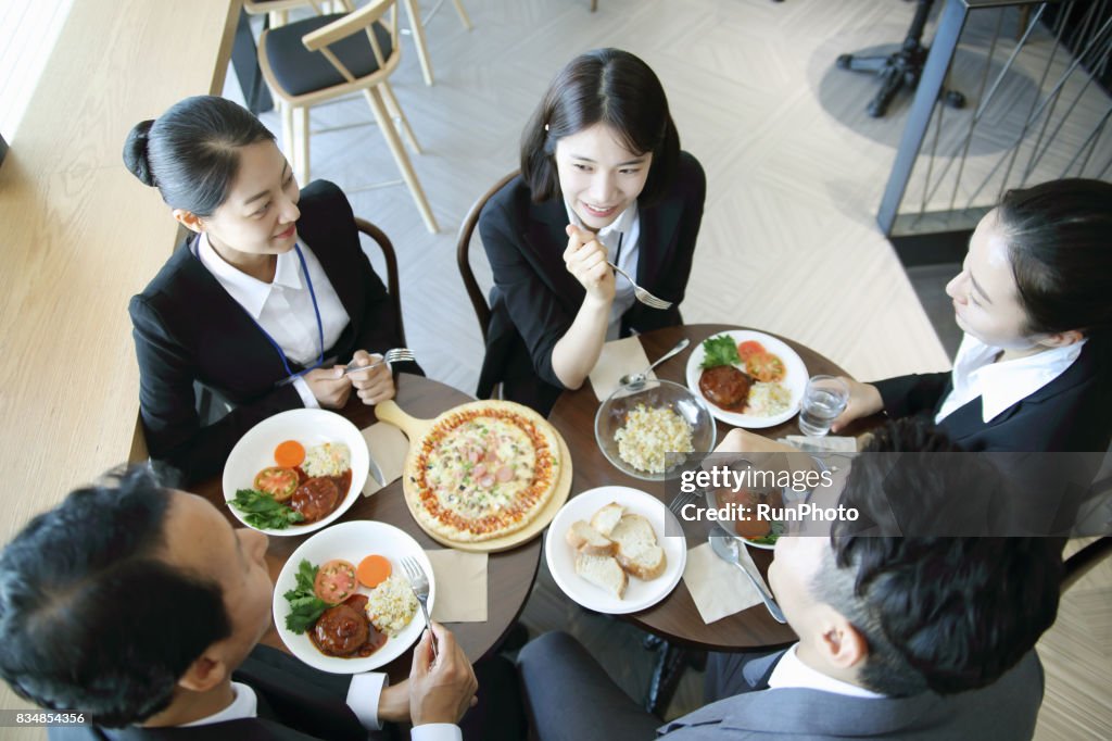 Scene where a businessman is listening to business woman's story while eating