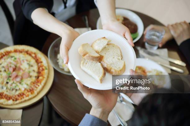 business woman who separates bread at a restaurant - passing giving stockfoto's en -beelden