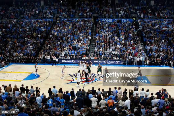 The Oklahoma City Thunder starting line up complete their first tip off as fans filling the arena watch the inaugural game against the the Milwaukee...