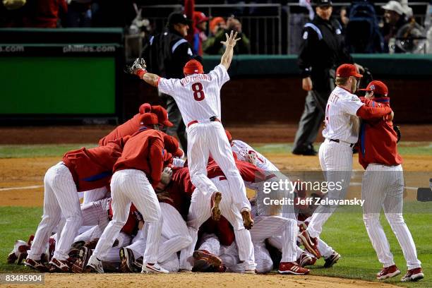 Shane Victorino of the Philadelphia Phillies dives on top of his teammates as they pile on top of closing pitcher Brad Lidge after they won 4-3 to...